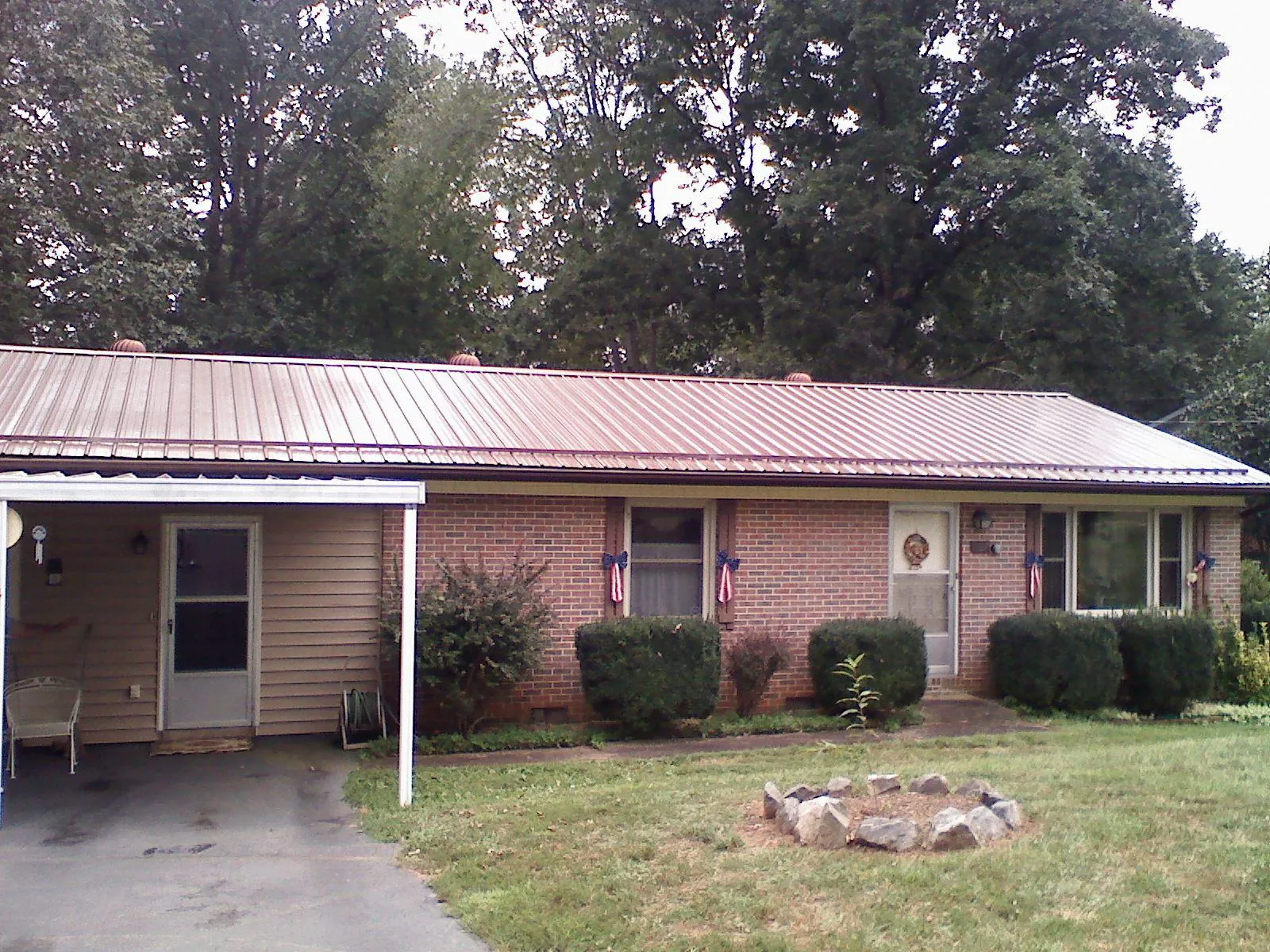 Bronze metal roof and carport on a brick ranch home — Roof Repair work by our crew in Addison